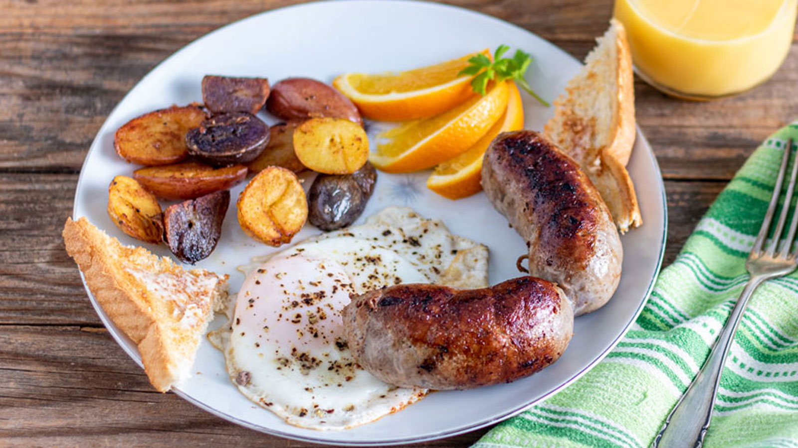 Venison breakfast sausage on a white plate with home fries and eggs..