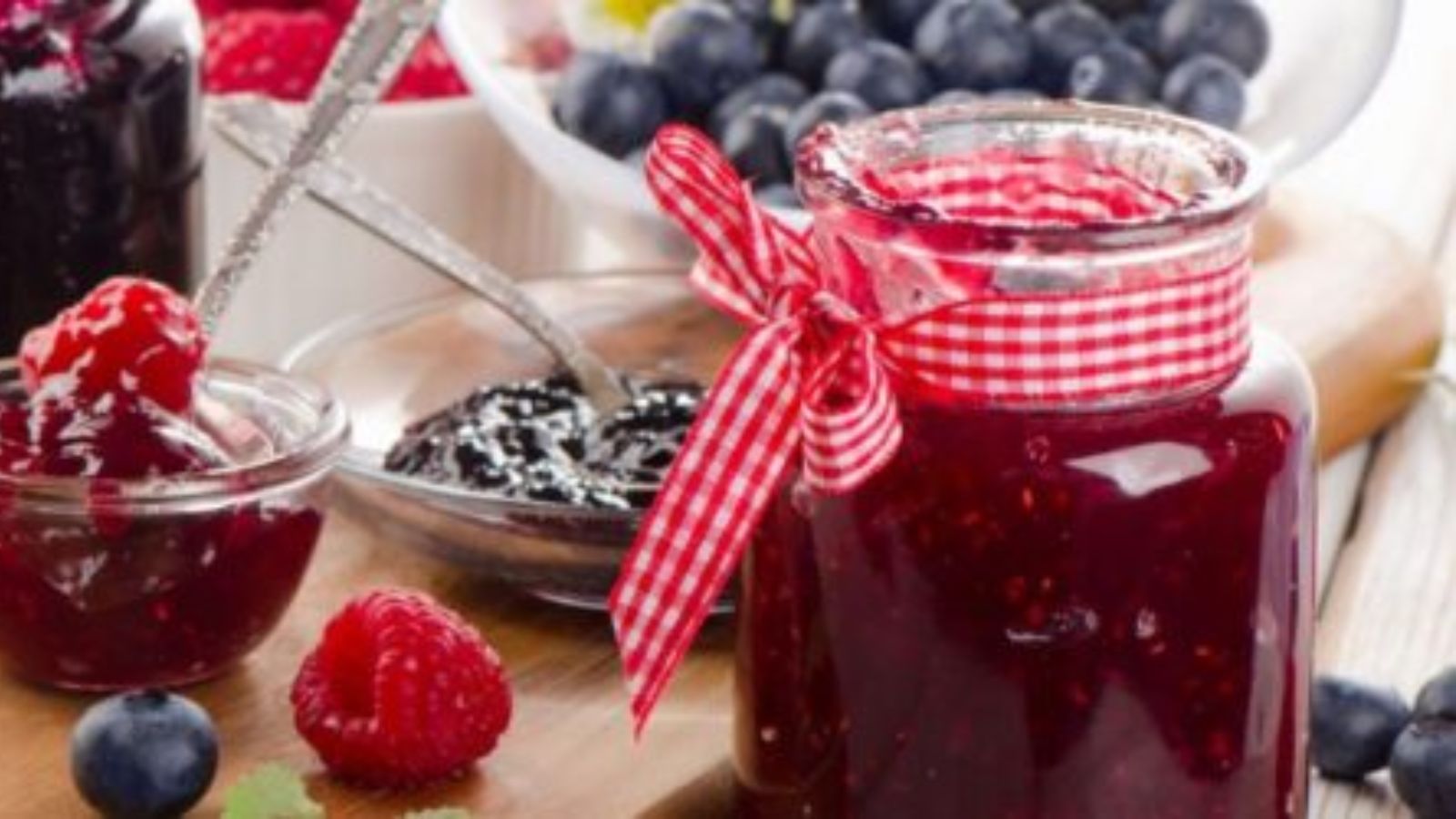 Jar of jam with a red checkered ribbon tied to the top.