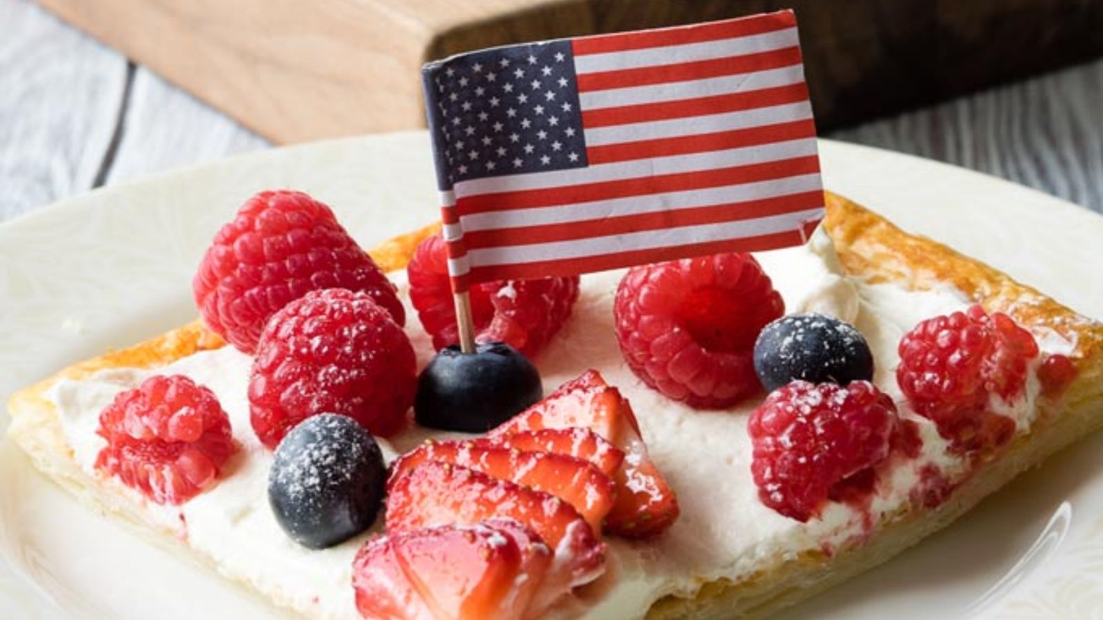 Bread with berries on top and usa flag.