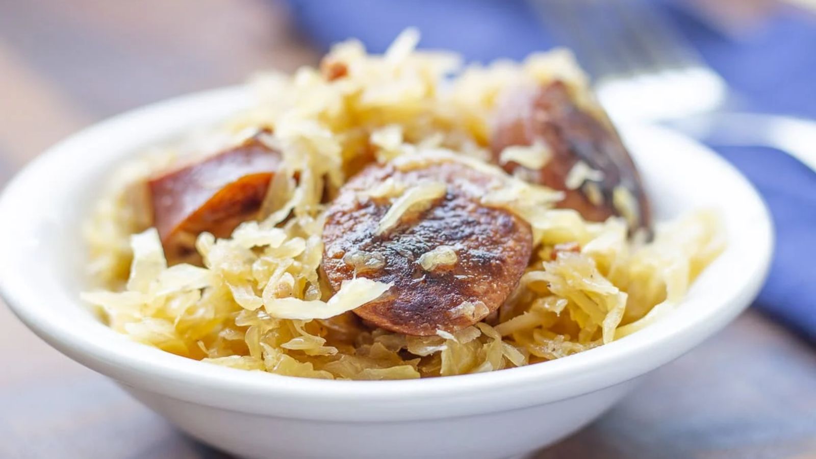 Sausage and sauerkraut in a white bowl.