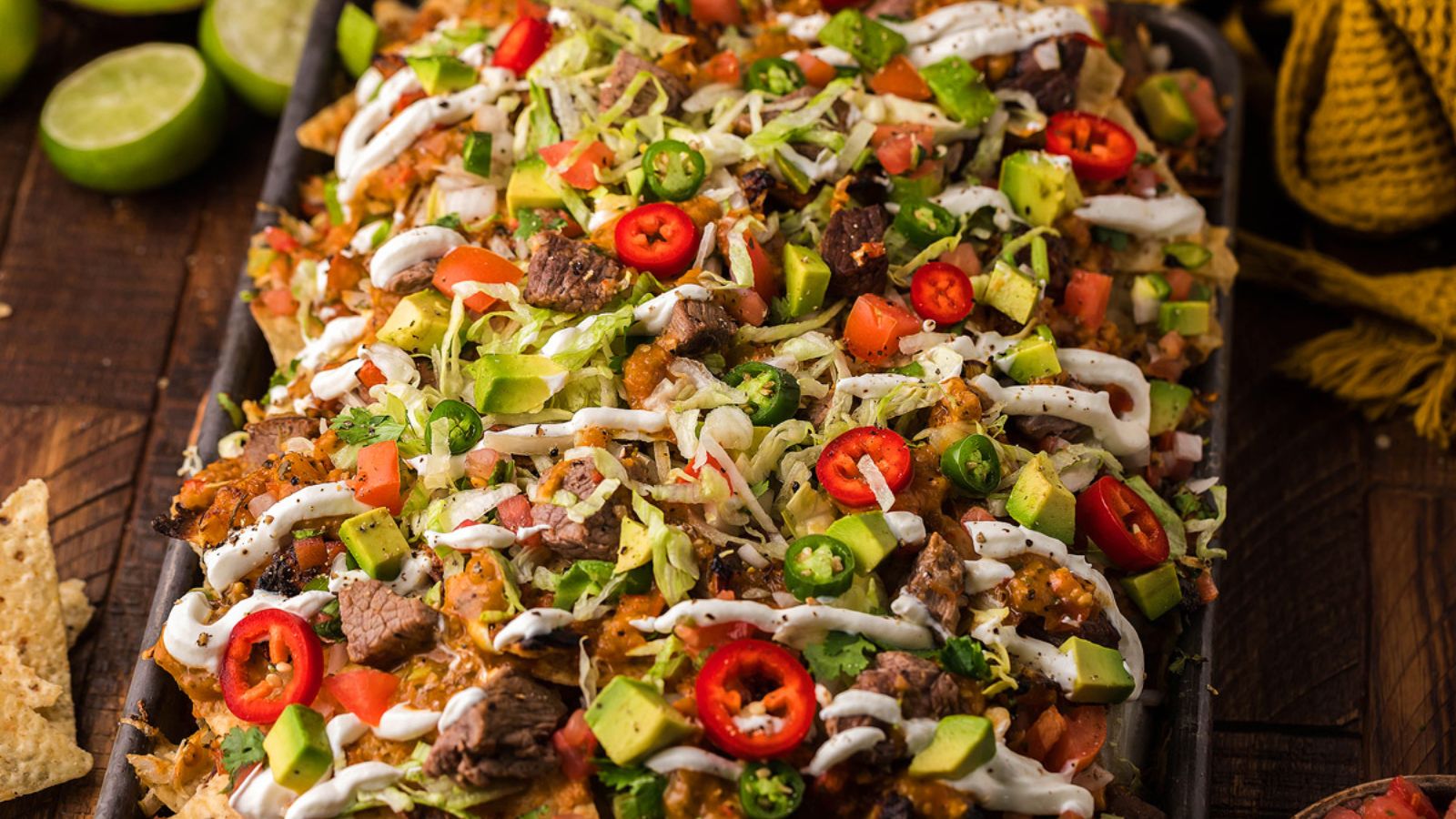 Steak nachos with chopped chilis on top.