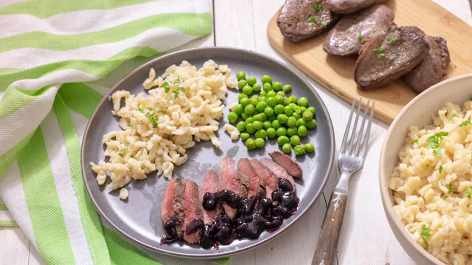 Sliced duck with side dishes dinner plate.