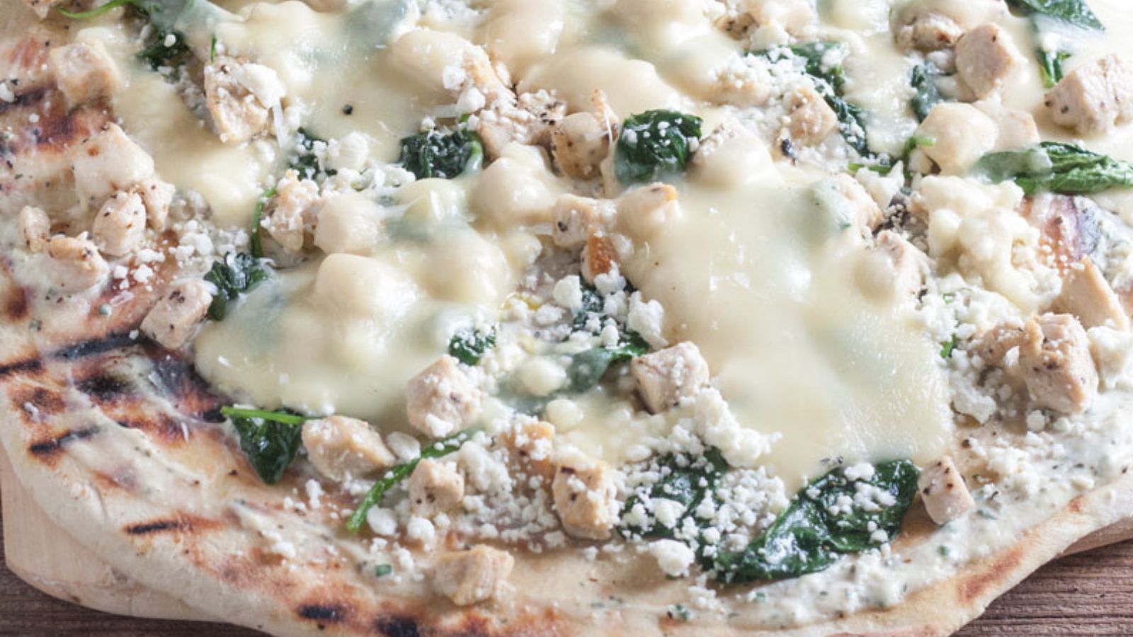 Close up of chicken and spinach pizza.