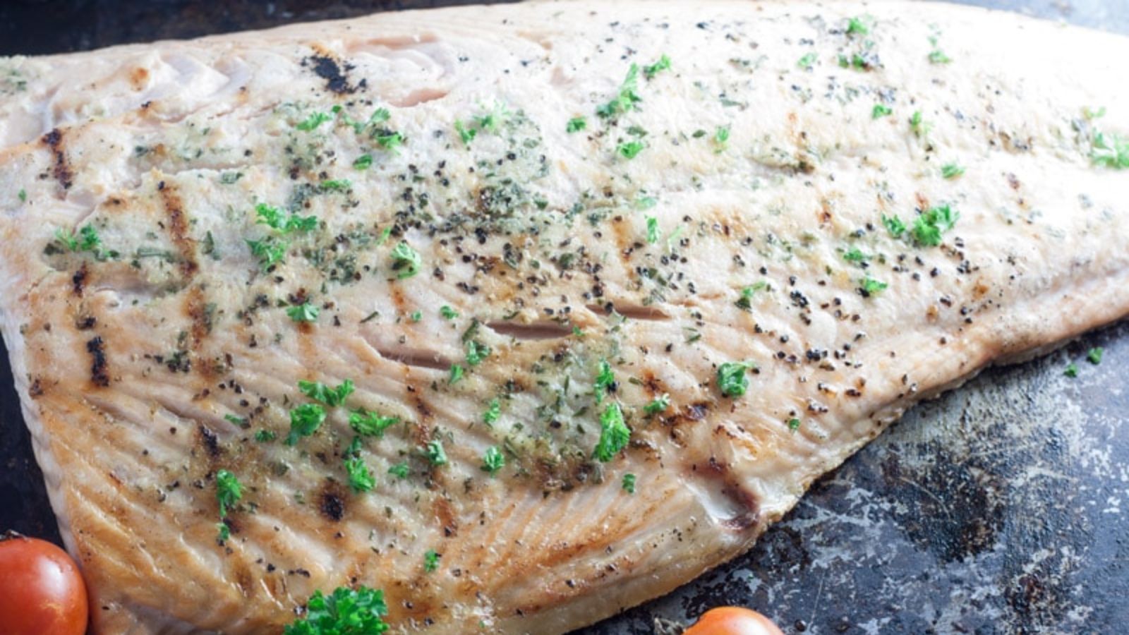 Garlic salmon with parsley and pepper on top.