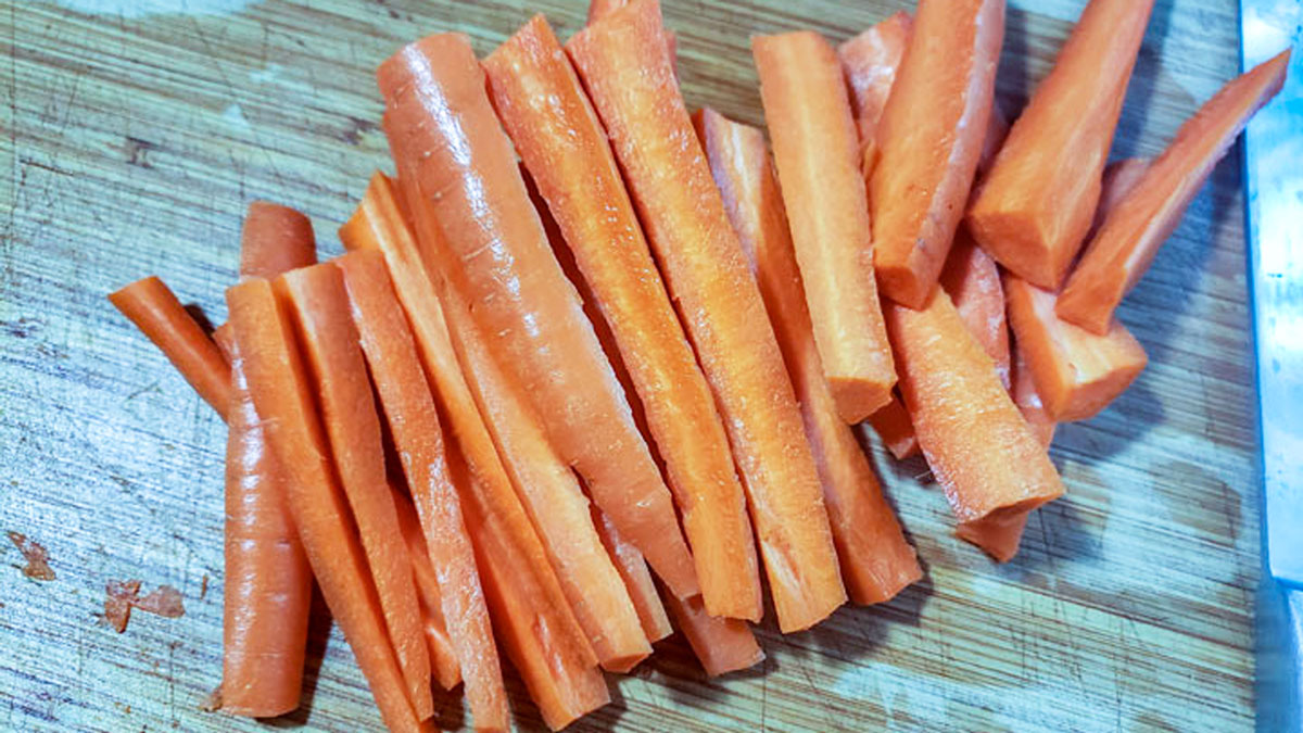 Cut up carrots on a cutting board.