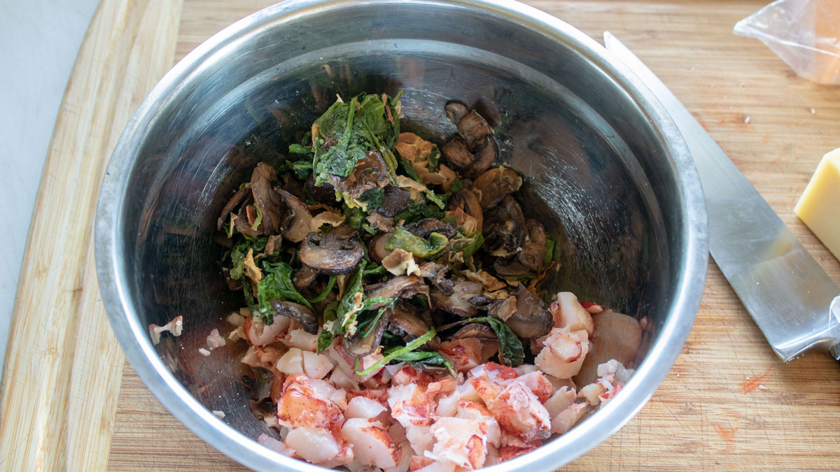 Spinach filling and lobster meat in a bowl.