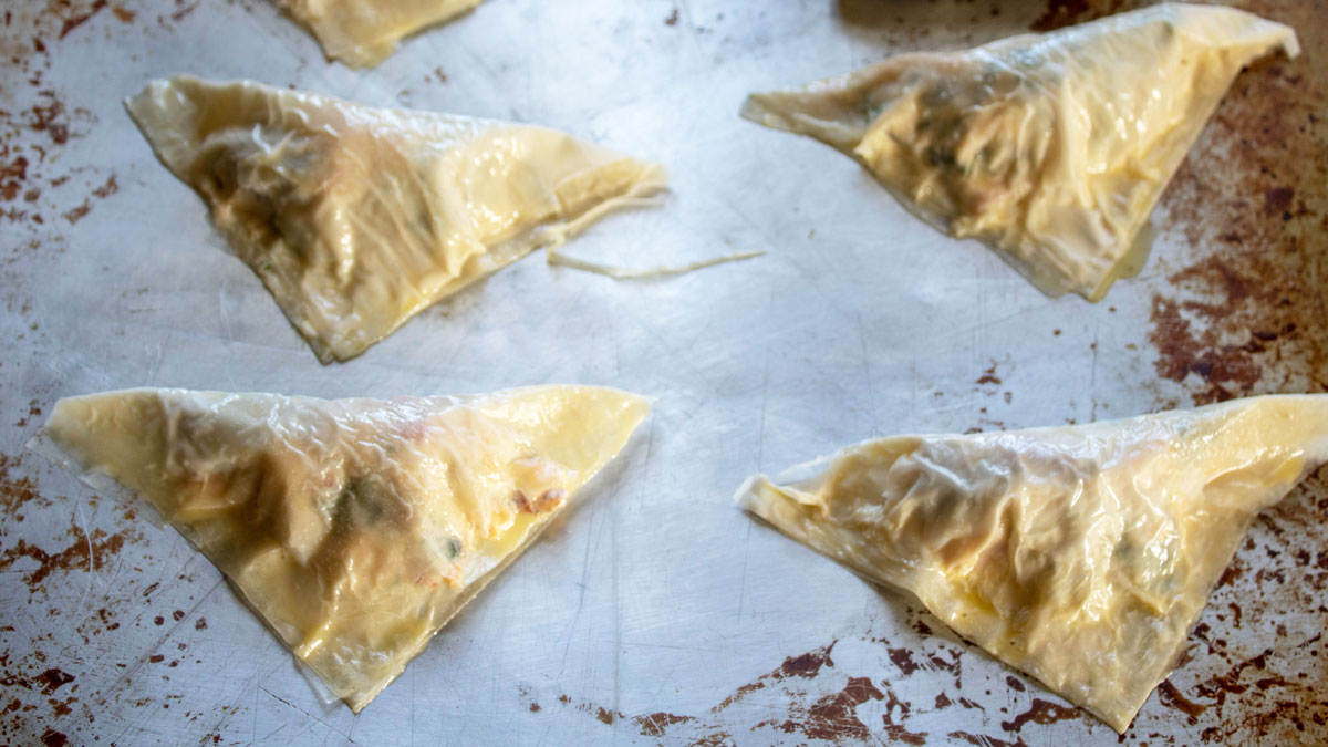 Appetizers folded into triangles filled with lobster filling.
