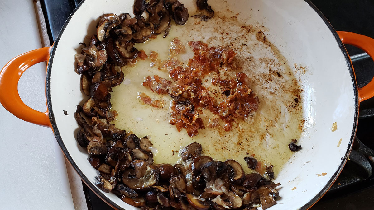 Pancetta added to the pan with the browned mushrooms.