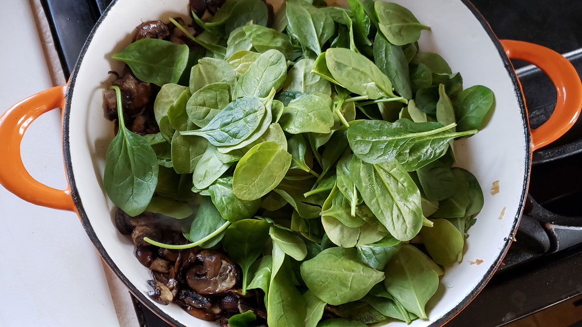 Spinach added to the mushroom pan.