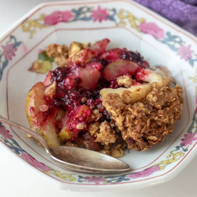 Pear and blackberry crisp in an antique bowl.
