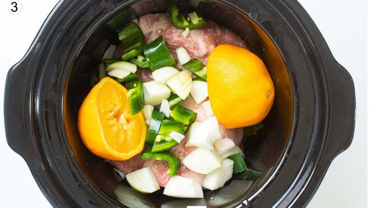Vegetables and orange in the crockpot with the pork.