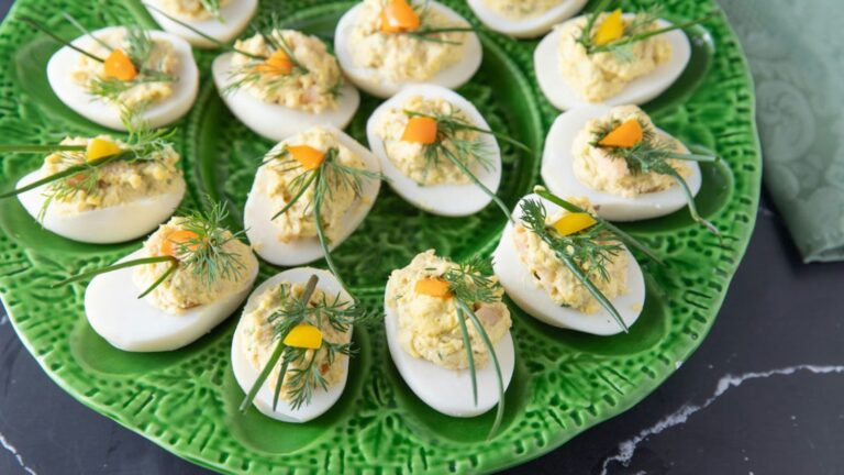 Deviled eggs garnished with fresh dill and chives.