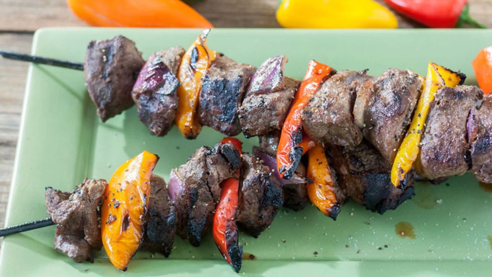 Two skewers with hunks of venison, re, orange and yellow bell pepper grilled to perfection.
