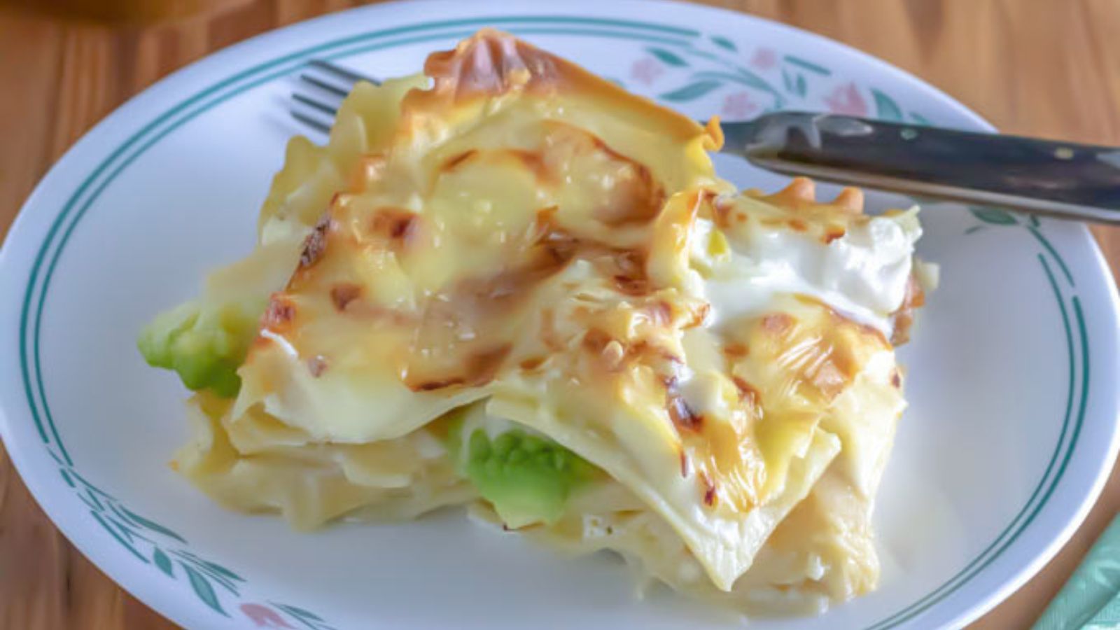 white lasagna with sausage and romanesco in a shallow white bowl.