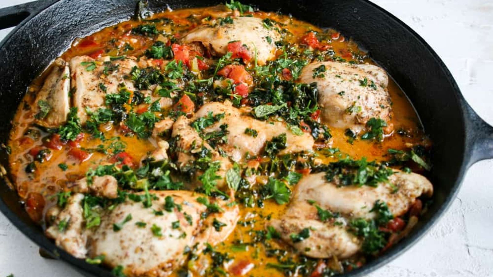 Chicken with veggies in a pan.