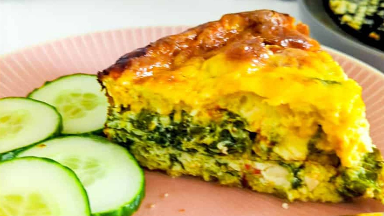 Sliced quiche with cucumber on the side.