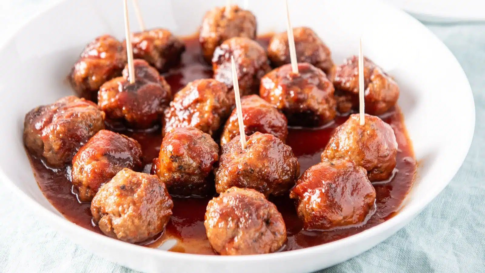 Meatballs with sticks on a plate.