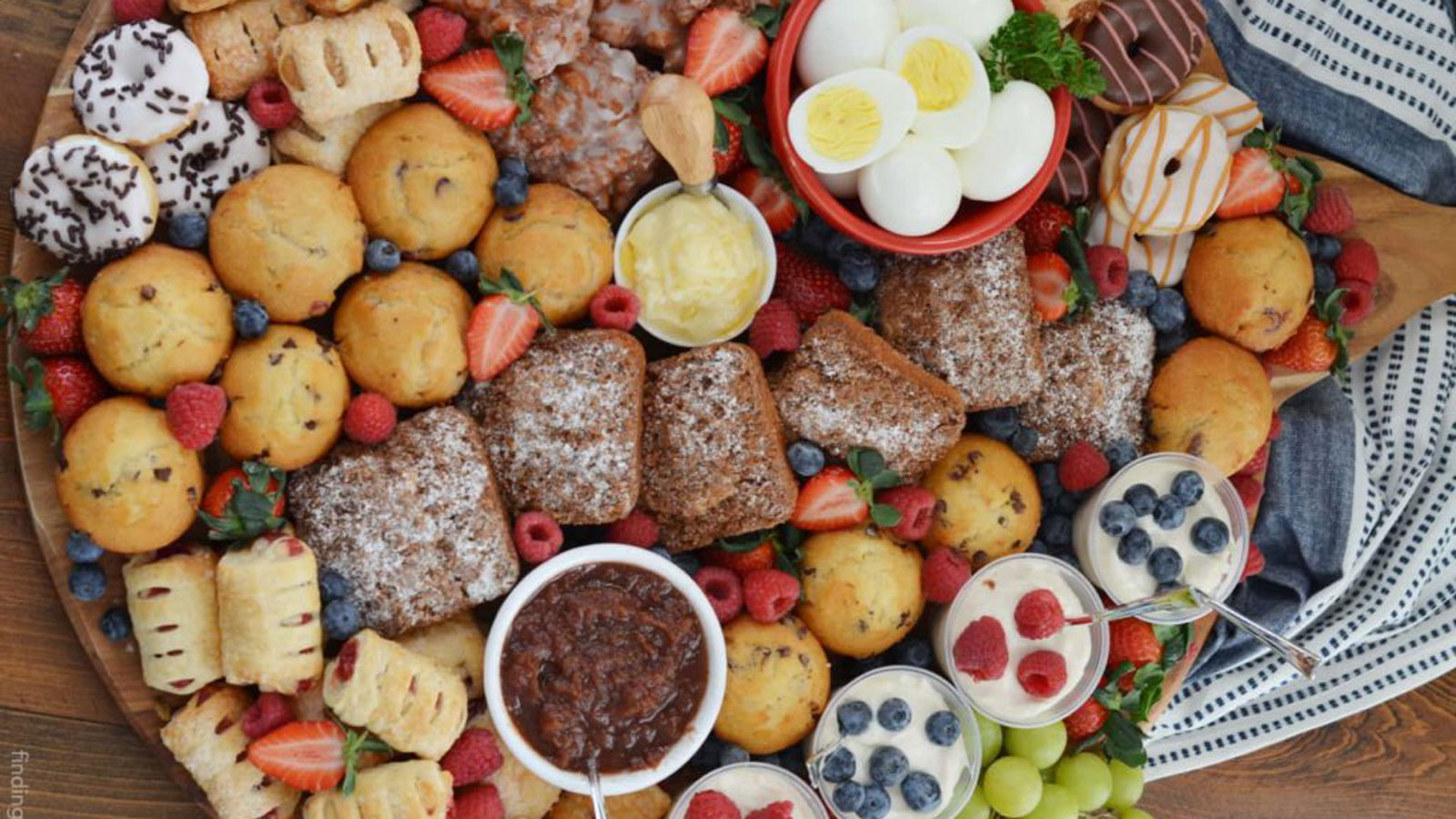 Assorted breakfast baked goods and fruit on a platter.