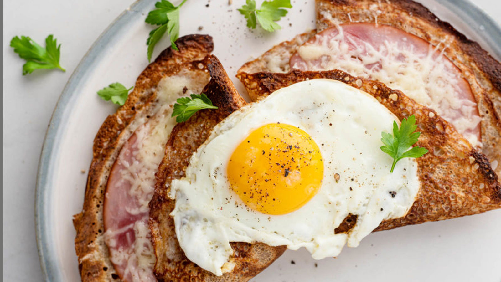 Crepes filled with ham and cheese and topped with an egg.