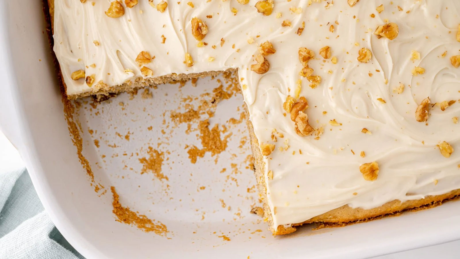 Cake with a piece cut out in a white baking dish.