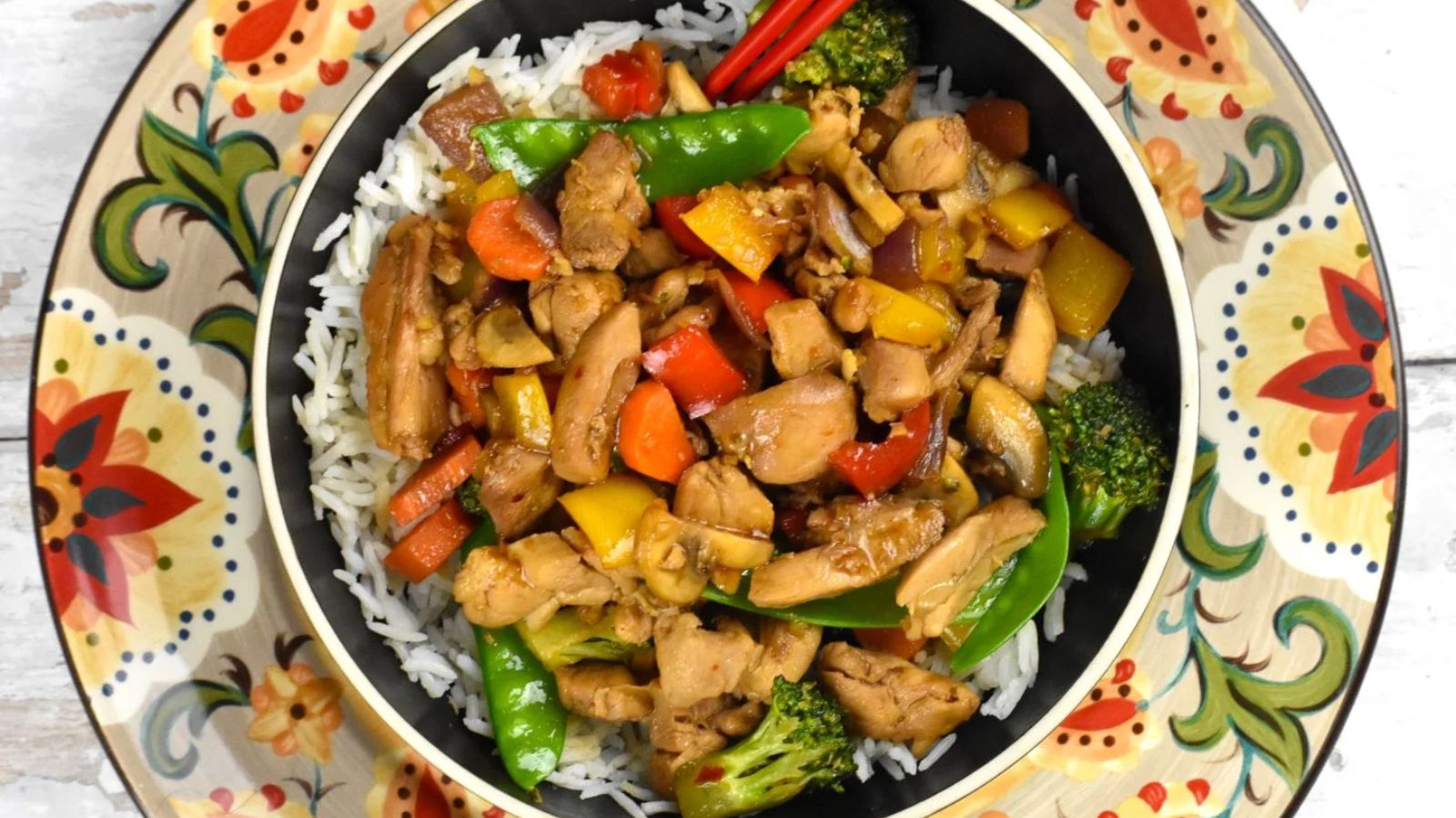 Chicken stir fry on a colorful plate.