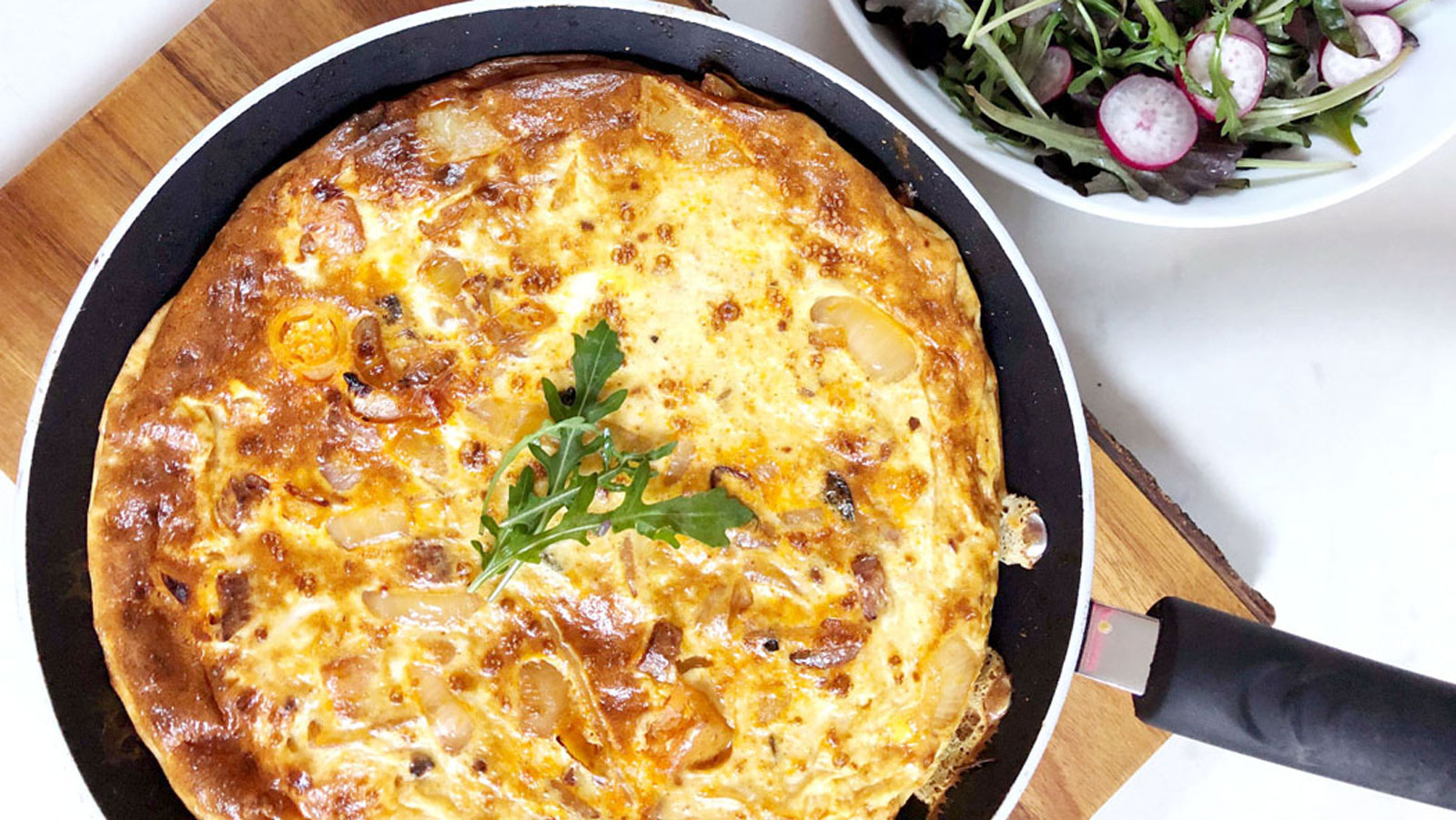 Frittata in a frying pan garnished with parsley.