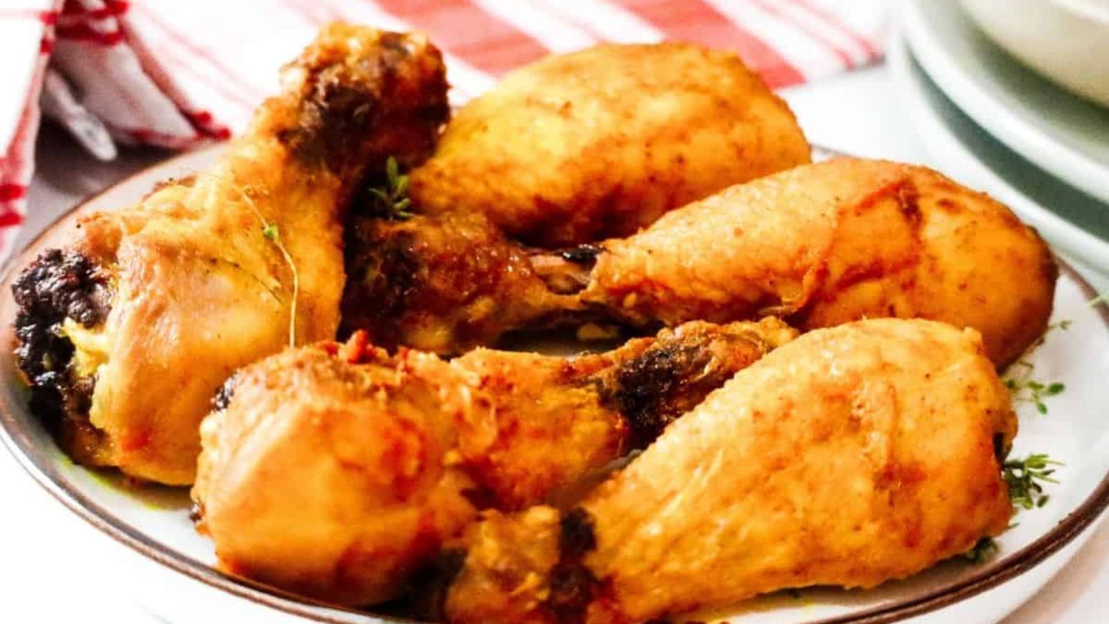 Baked chicken drumsticks on a plate.