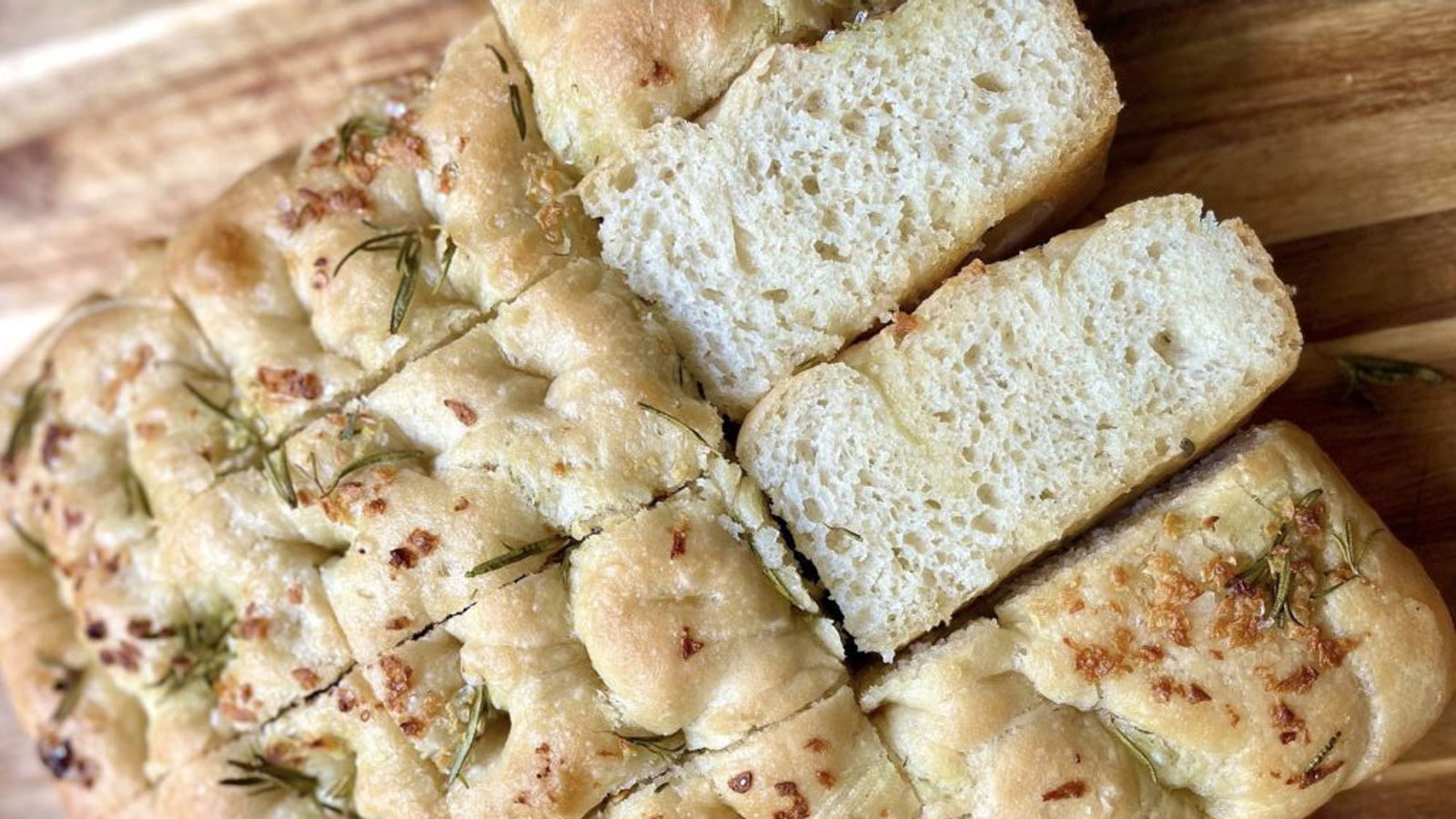  Focaccia topped with cheese and rosemary cut into squares.