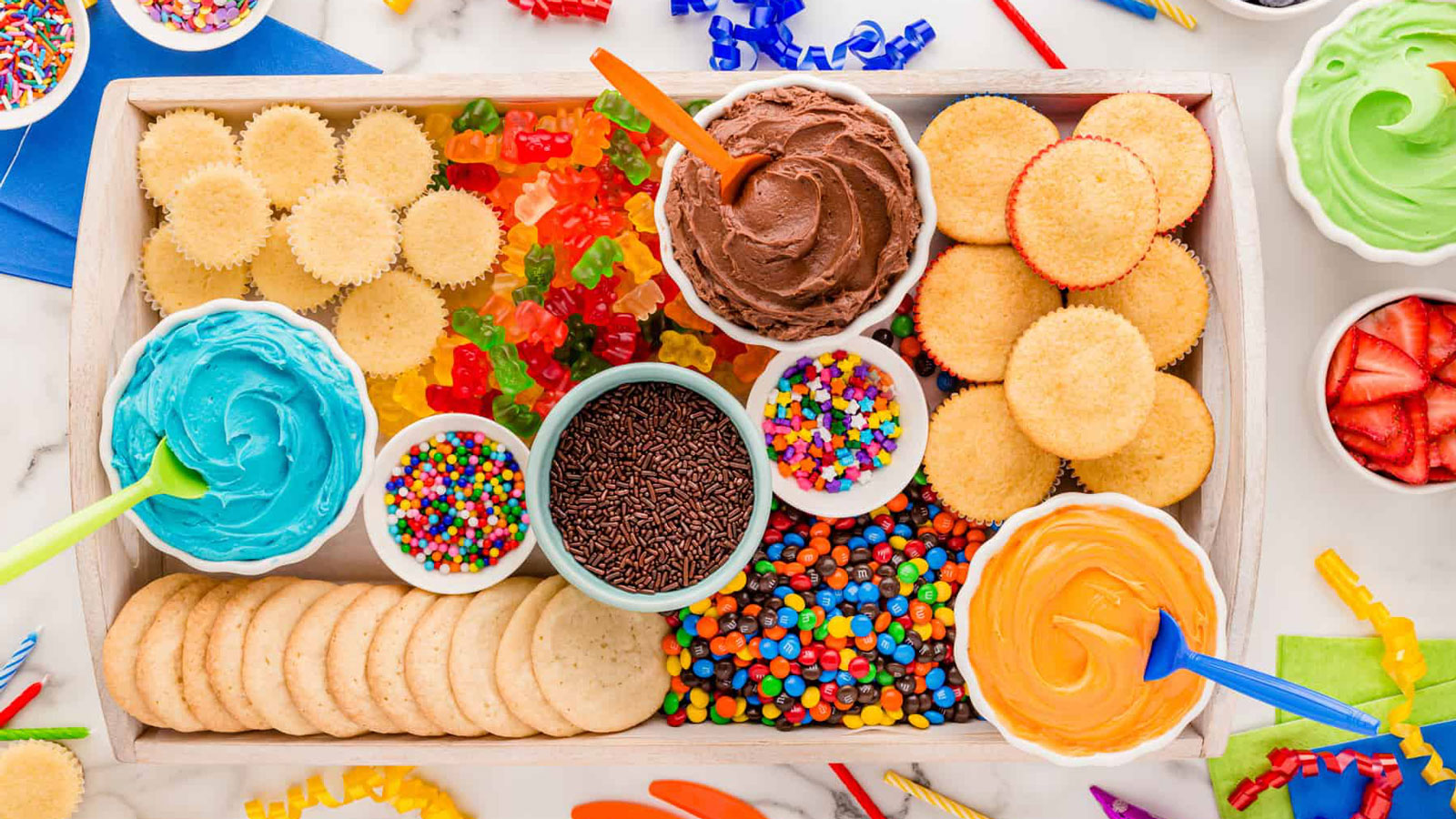 Assorted frosting and decorations on a board.