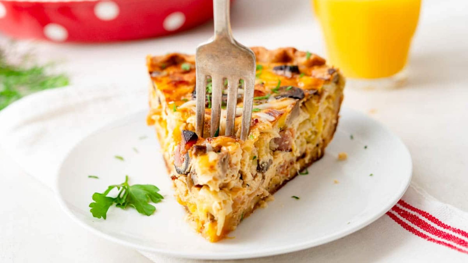 Ham and mushroom quiche on a plate.