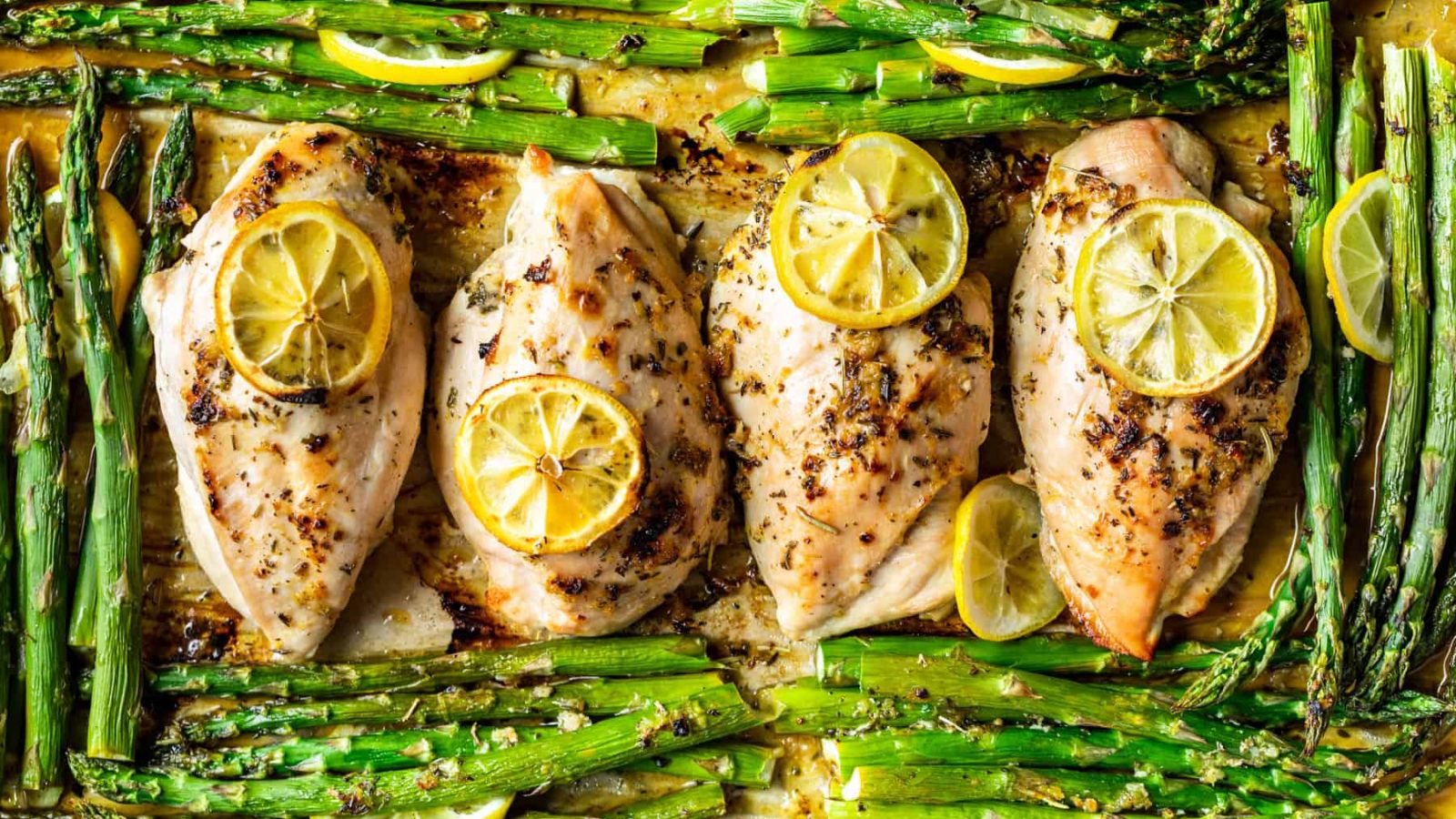 Chicken with asparagus and lemon on the sides.
