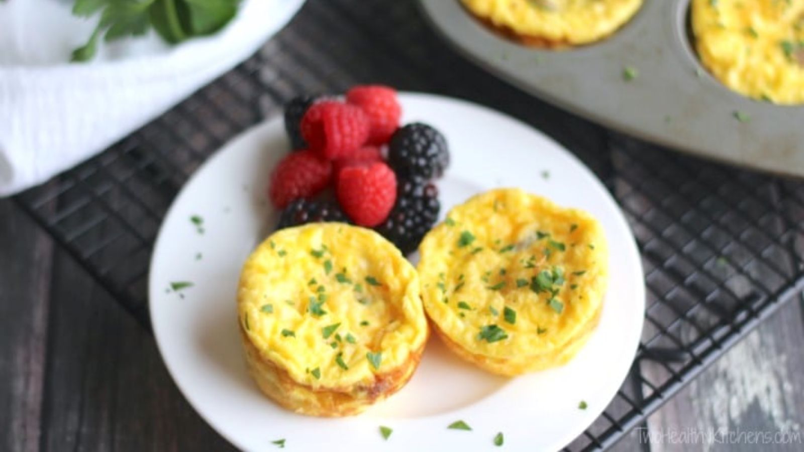 Crustless quiche cups with berries on the side.