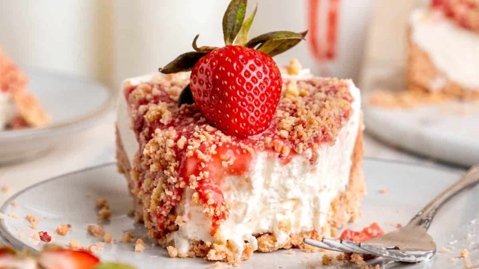 A slice of strawberry cheesecake on a plate.