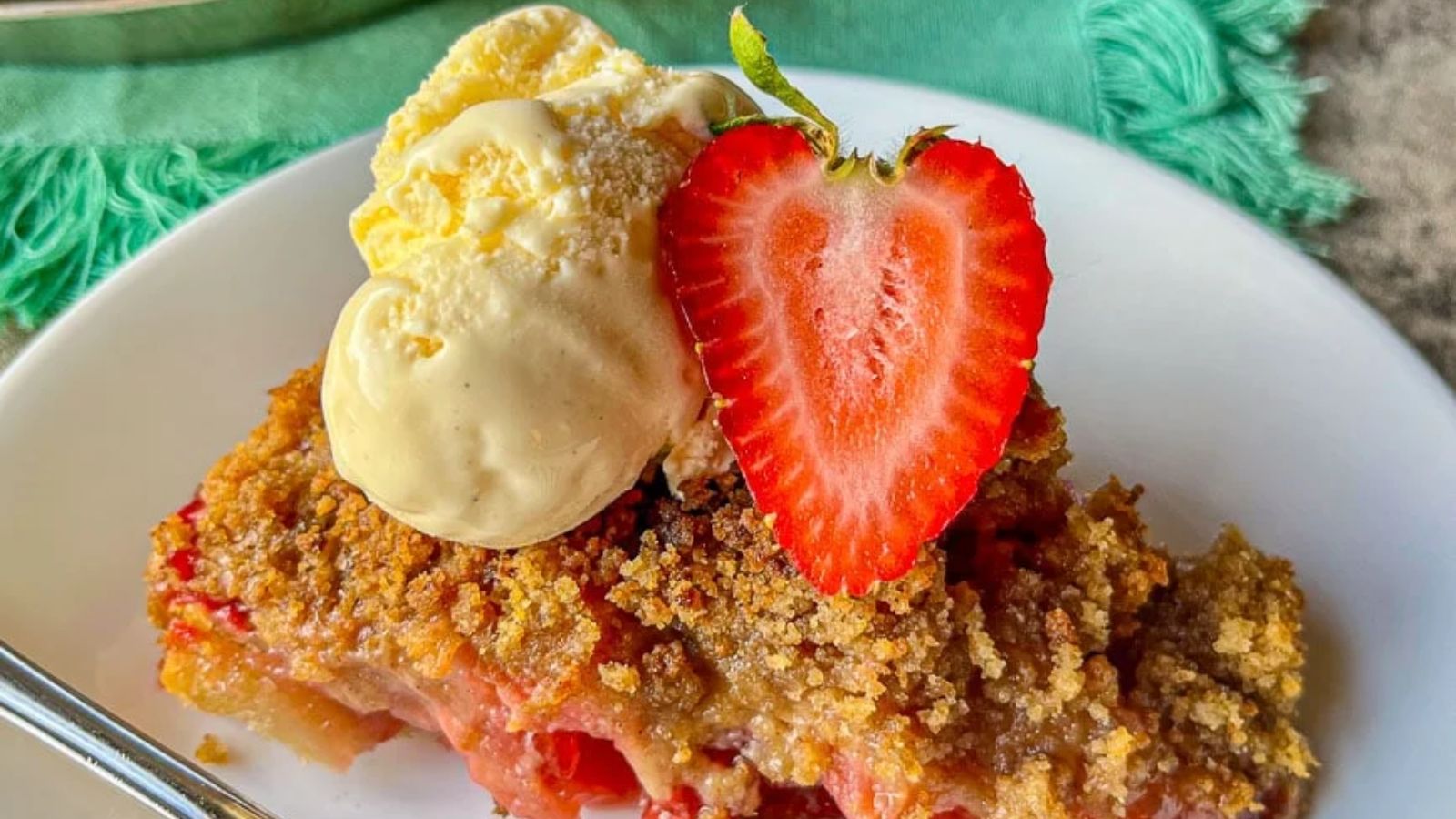 Old fashioned rhubarb pie with strawberry and ice cream on top.