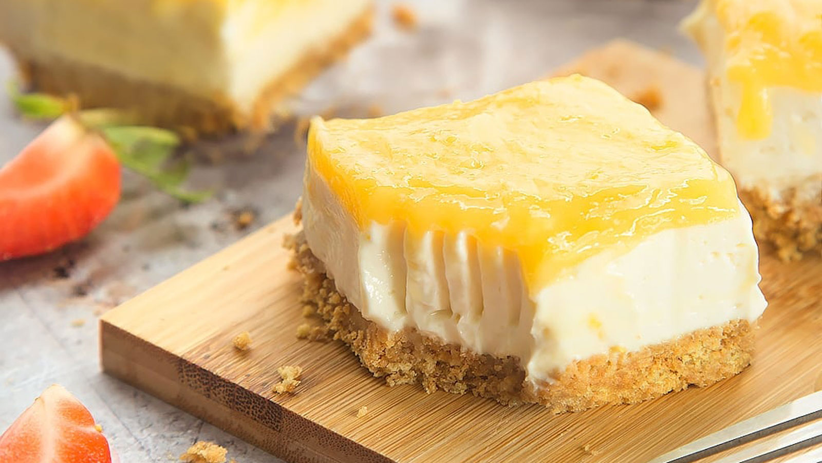 Lemon curd cheesecake bars on a cutting board.