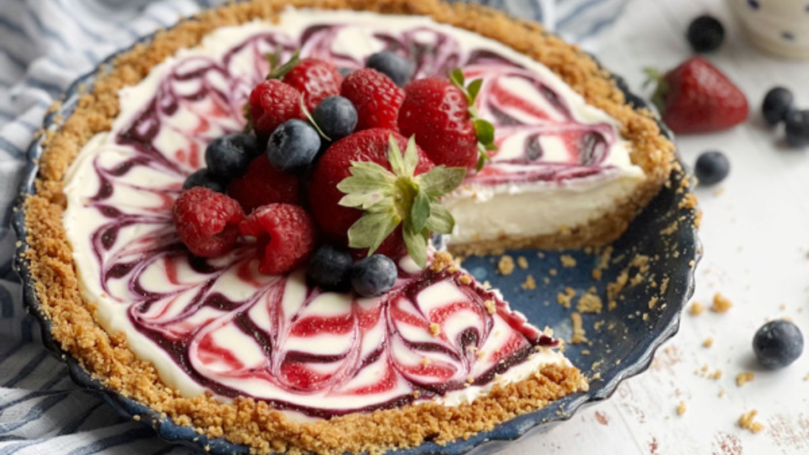 Cheesecake with a slice and berries on top.