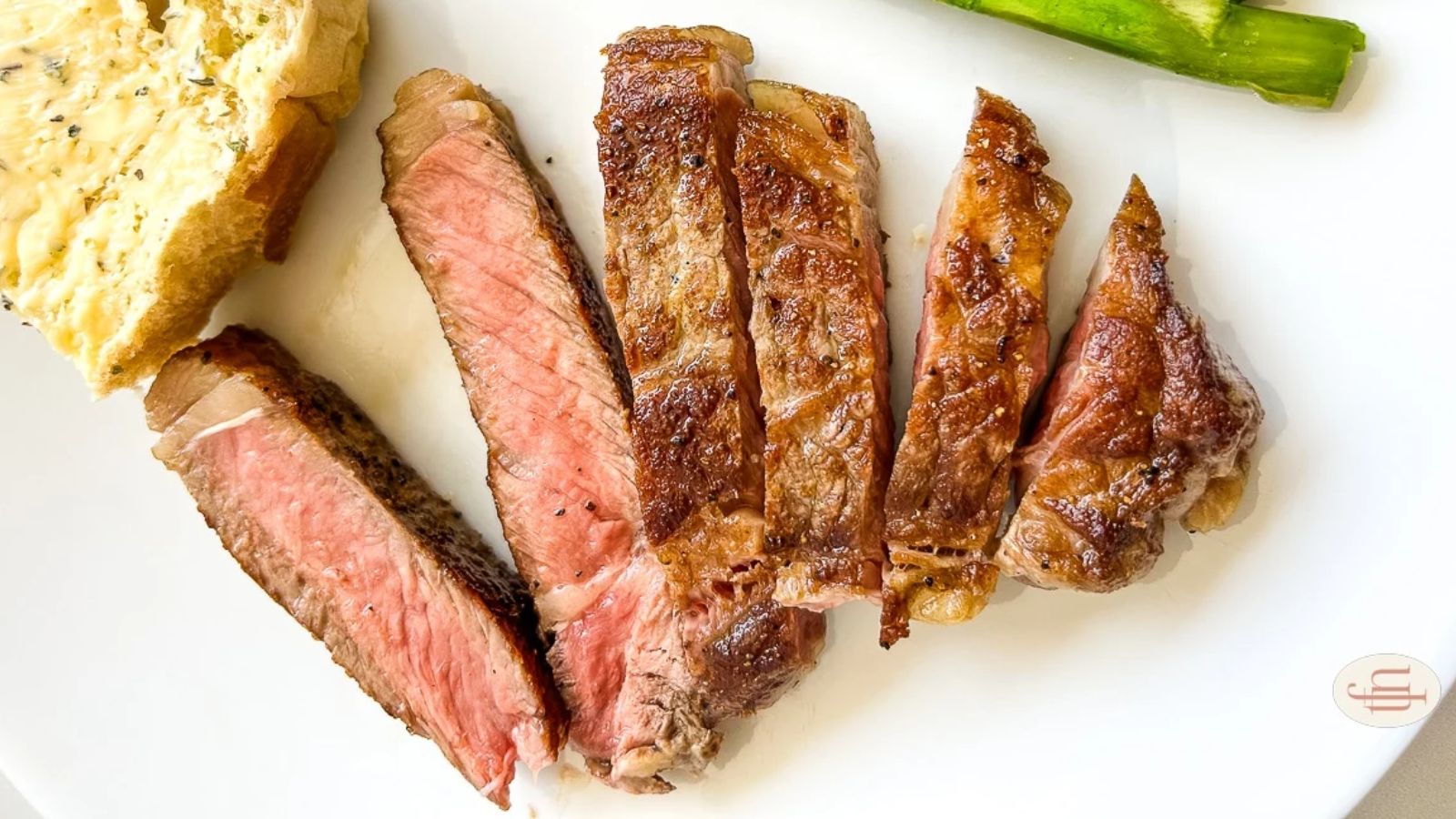 Steak on a plate with bread on the side.
