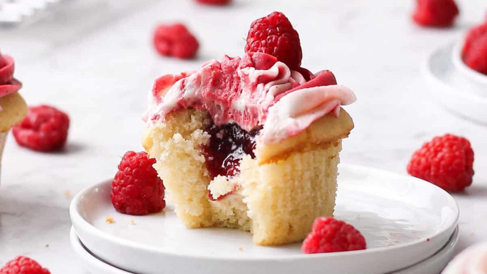 Raspberry almond cupcake with a bite.
