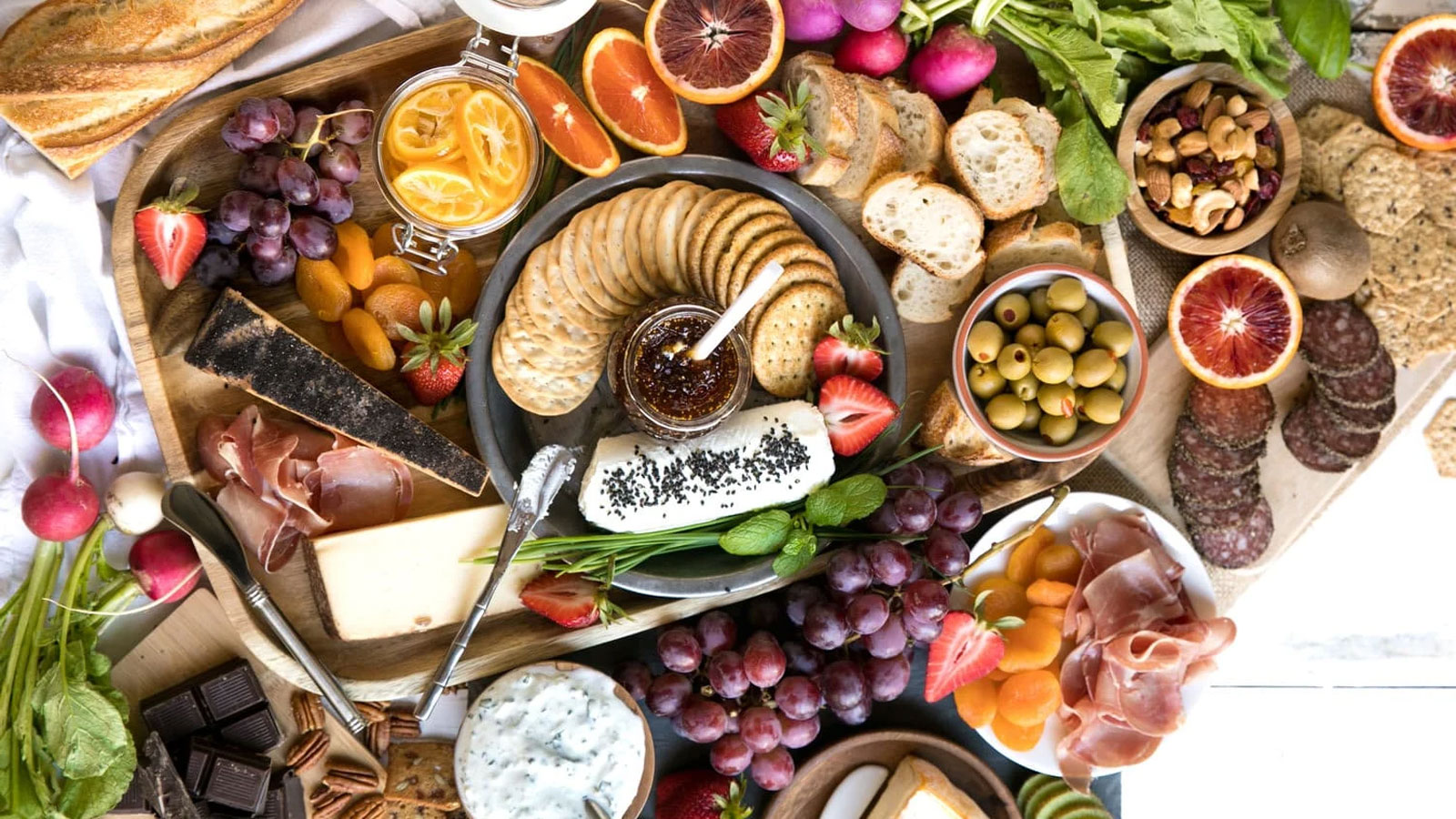 Boards with assorted meats, cheeses, and fruit.