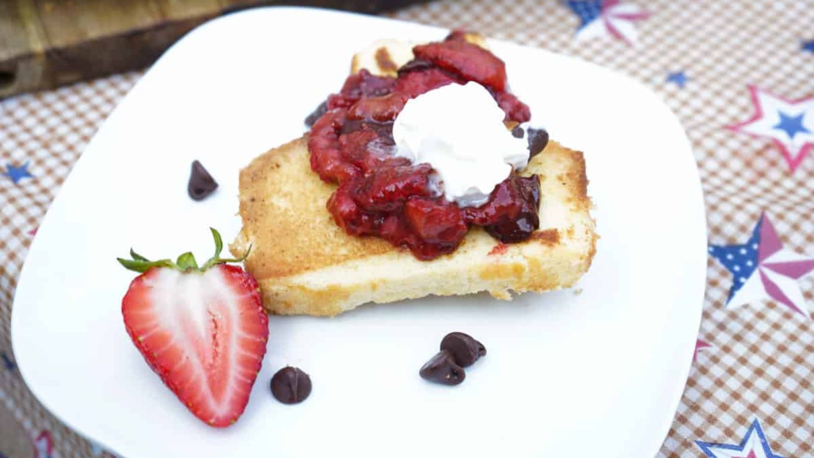 A slice of pound cake with strawberries and a scoop of ice cream on top.