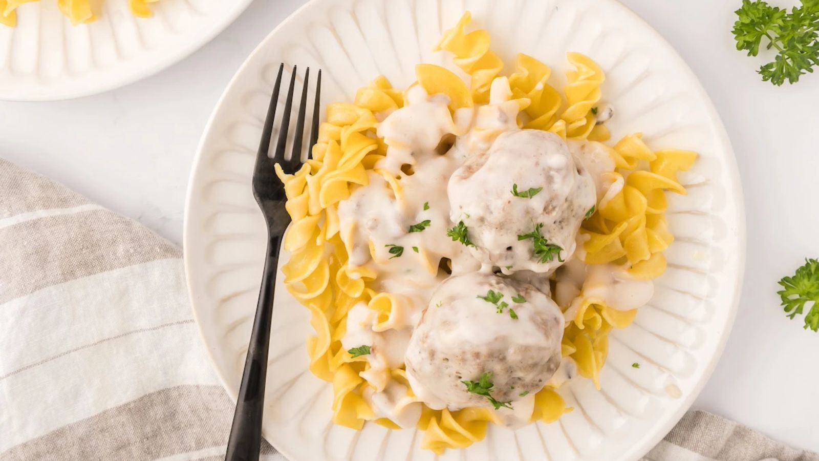 Pasta with meatballs and sauce on top.
