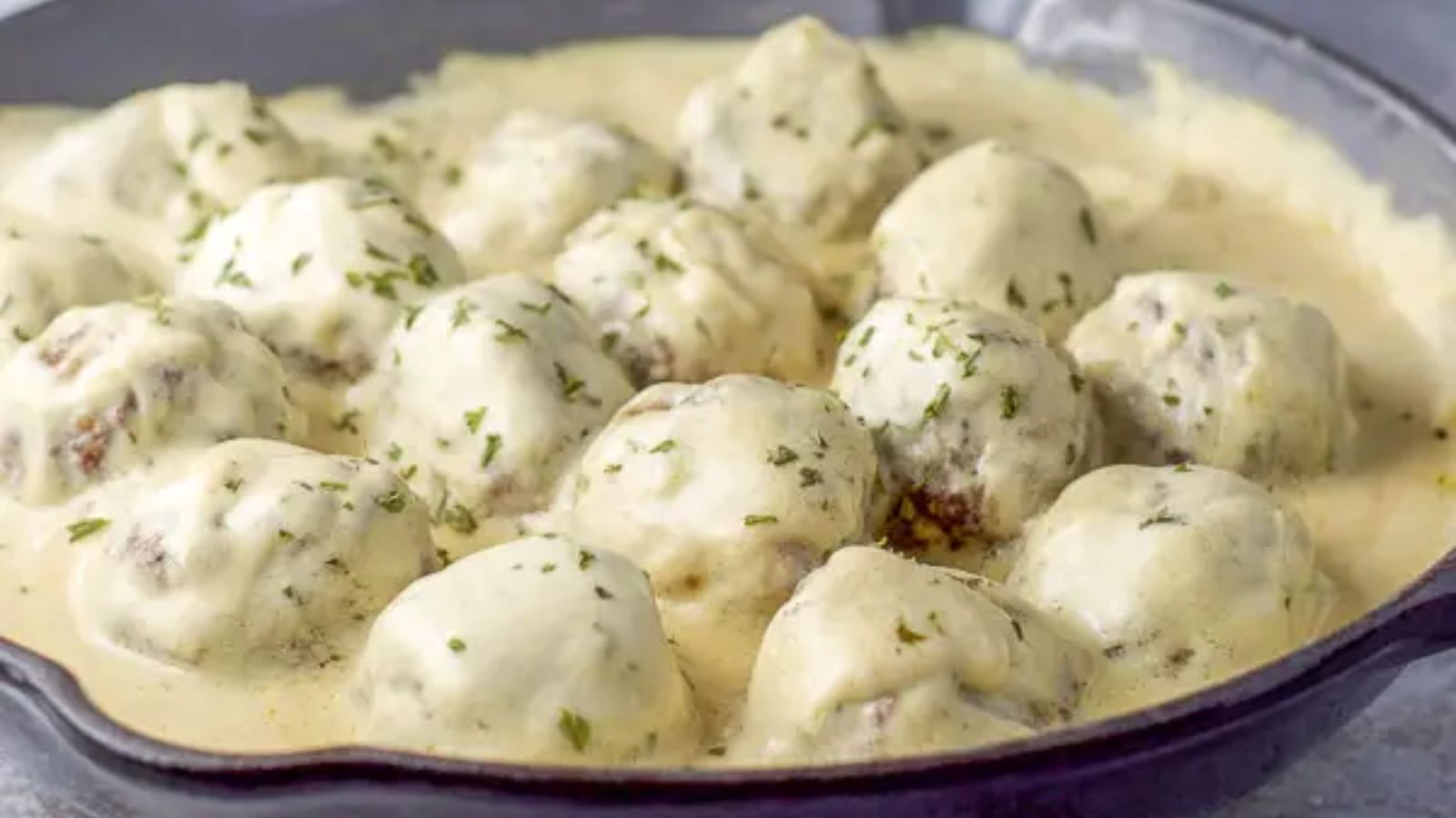 Swedish meatballs with sour cream sauce in a pan.