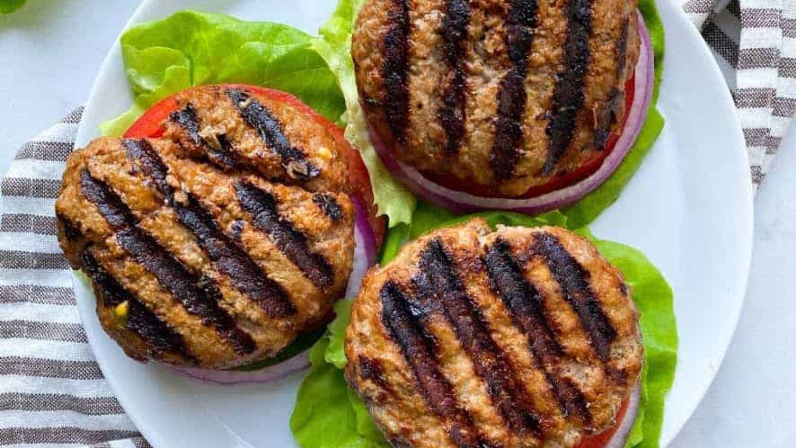Grilled burgers with lettuce.