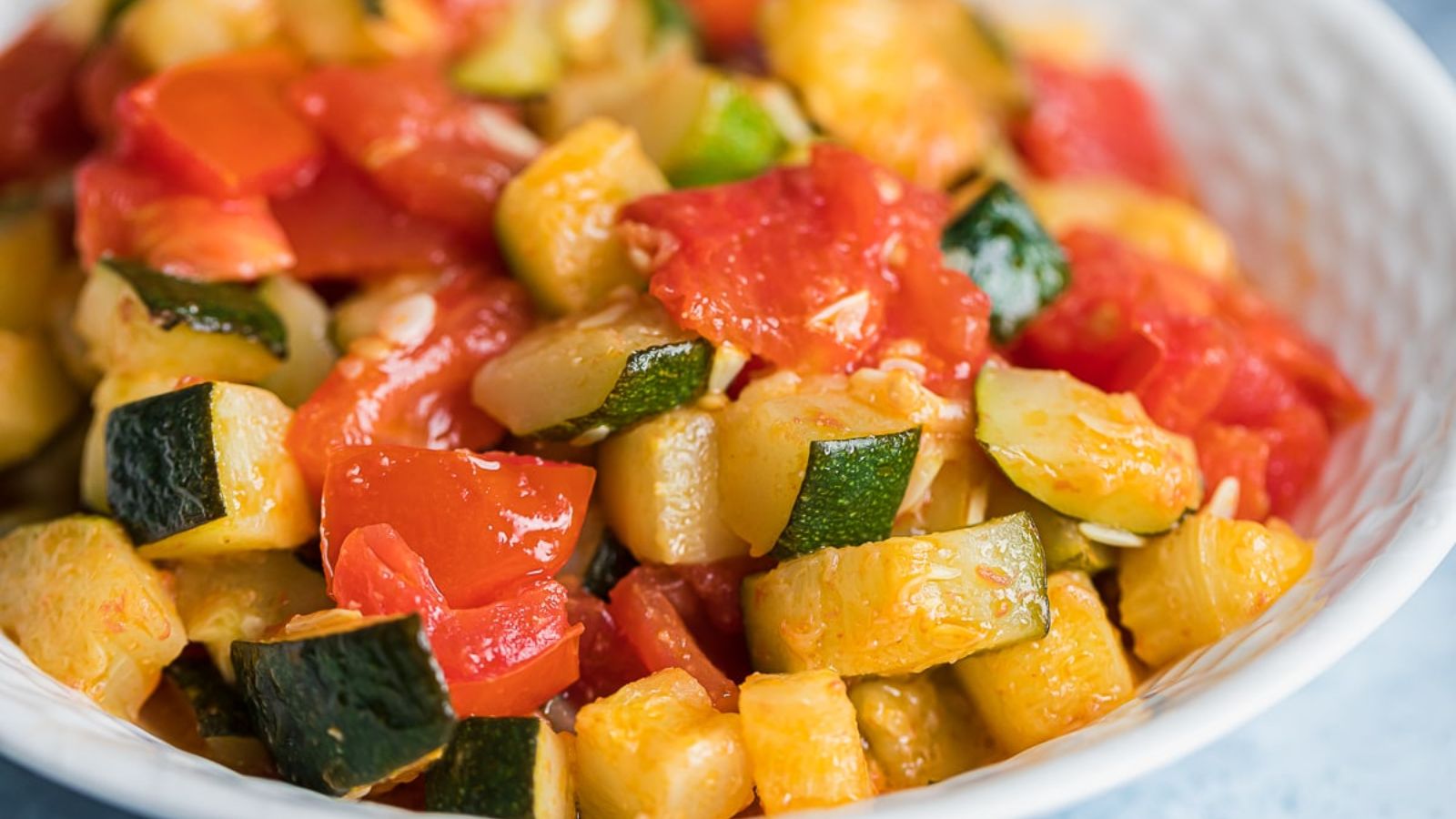 Zucchini and tomatoes in a bowl.