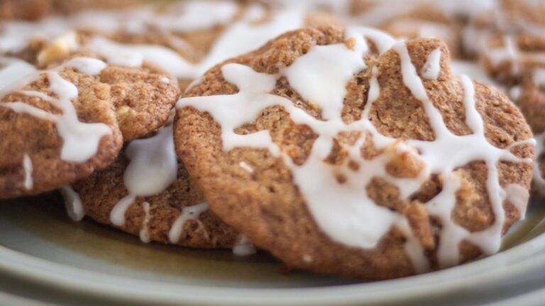 Iced apple cookies on plate with green trim.