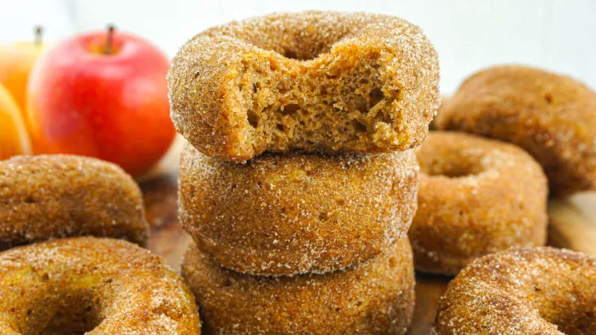  Doughnuts in a stack with a bite taken out of the top one.