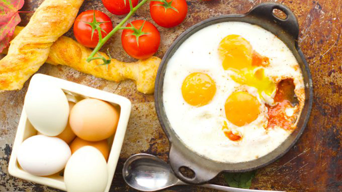 Three eggs in a cast iron baking dish.