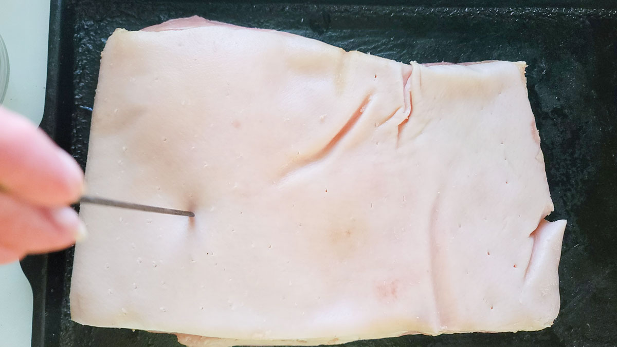 Poking holes in the skin with a metal skewer.