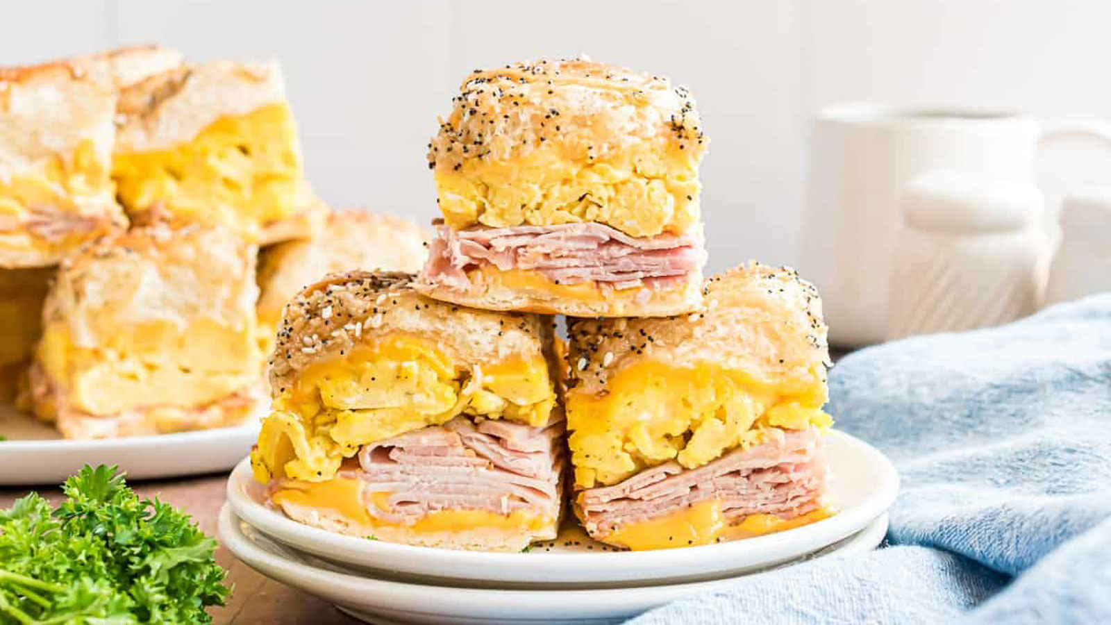 Slider sandwiches stacked on a white plate.