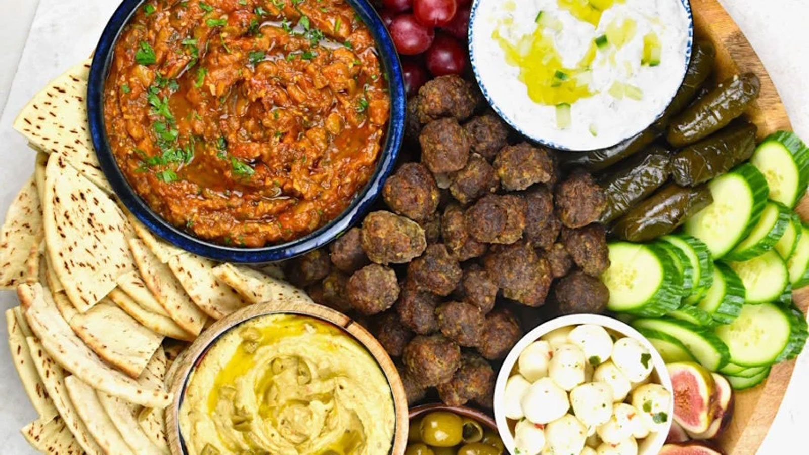 Board with hummus, falafel and sauces.